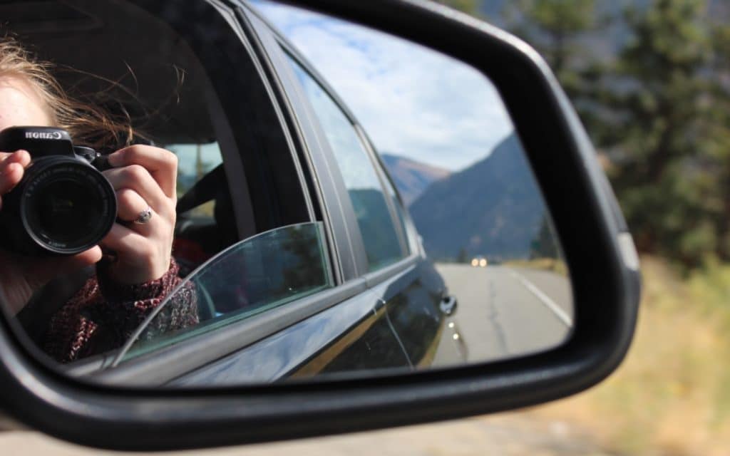 A woman takes a picture from a moving vehicle