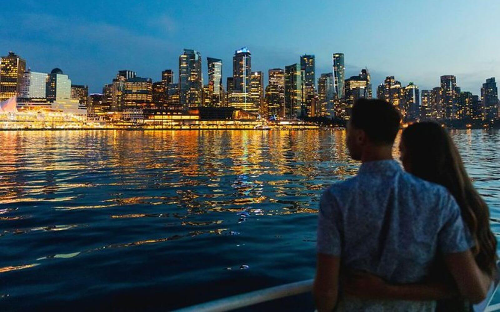 a couple looking at the vancouver skyline from the new years eve boat cruise