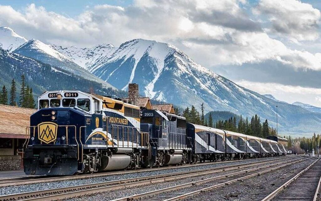 the vancouver to banff train on the tracks in front of the rocky mountains on how far is banff from vancouver