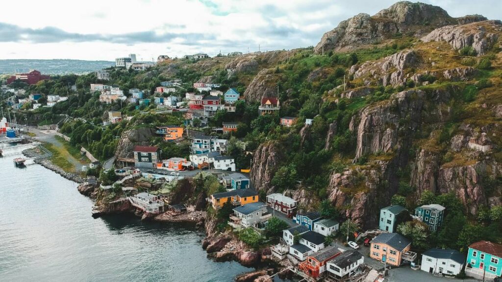 coastal newfoundland town with rocky mountains and coloured houses
