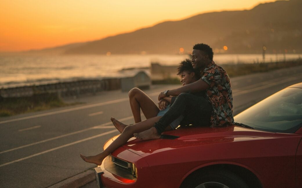 A couple enjoys the sunset along the water on a Los Angeles road trip from Vancouver.