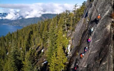 A group climbs a rock on the Via Ferrata Adventure near Squamish, BC.