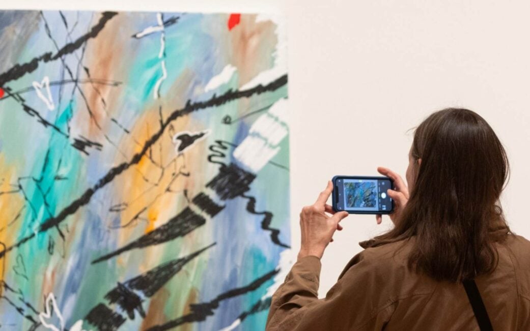 guest taking a photo of a painting at the audain museum in whistler
