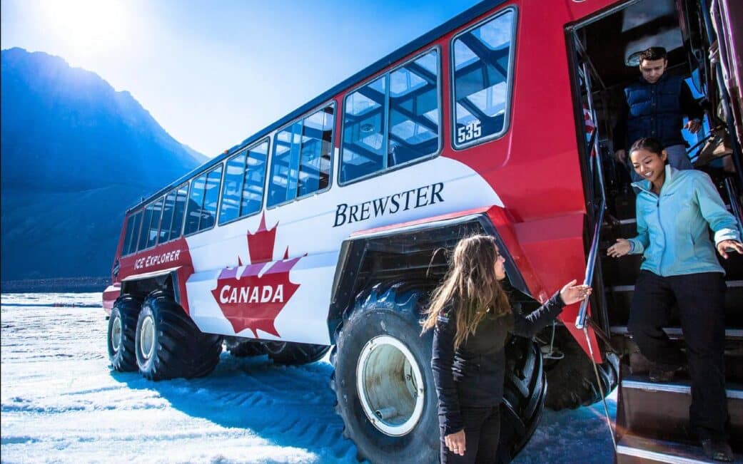 A tour group exits the ice explorer vehicle to walk on the Crowfoot Glacier.