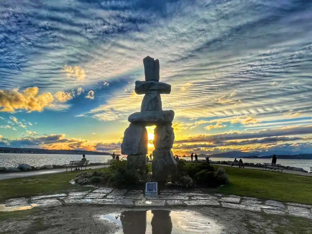 one of the inukshuks in vancouver at sunset with dramatic clouds and ocean view in the background how far from seattle washington to vancouver canada near english bay