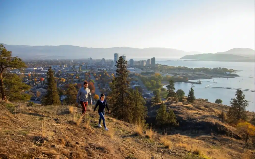 A couple hike Kelowna's Knox Mountain Park to check out the sunset.