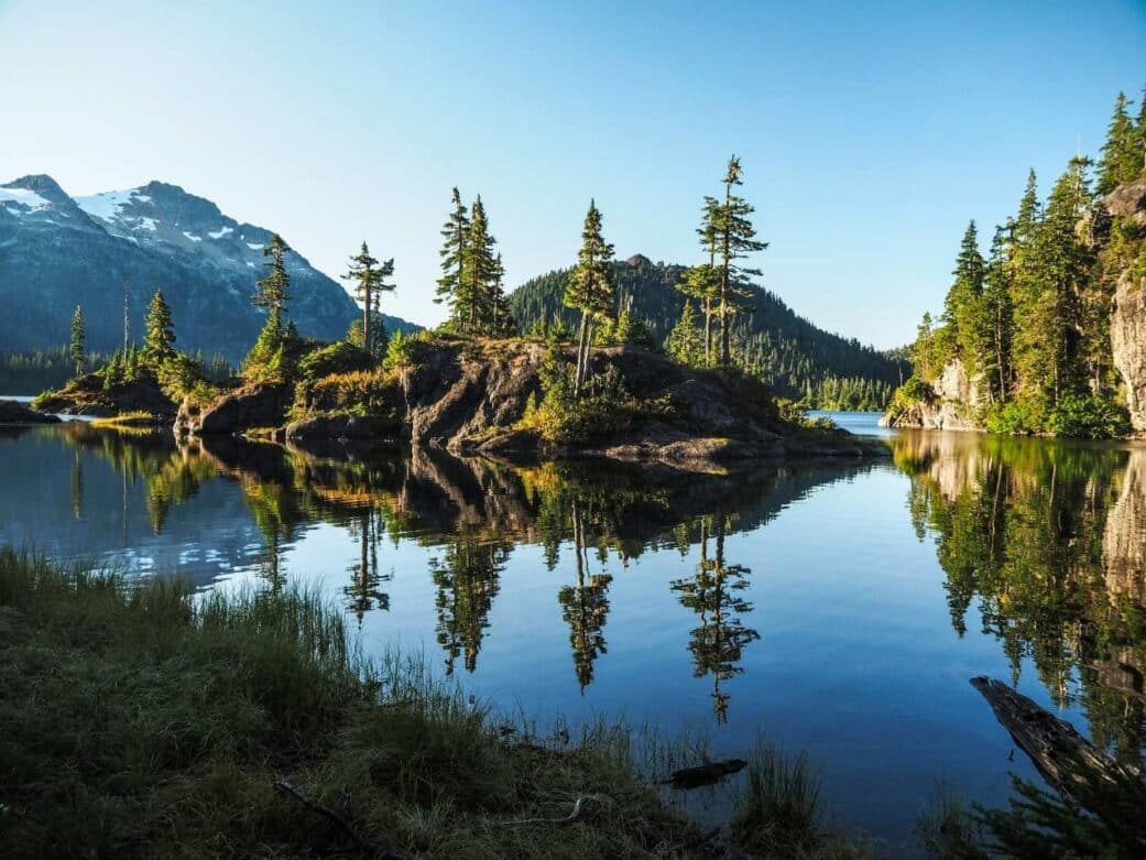 amazing scenery of vancouver island with crystal clear water, large trees hovering over the island perfect on how to get to vancouver island from vancouver where is vancouver island