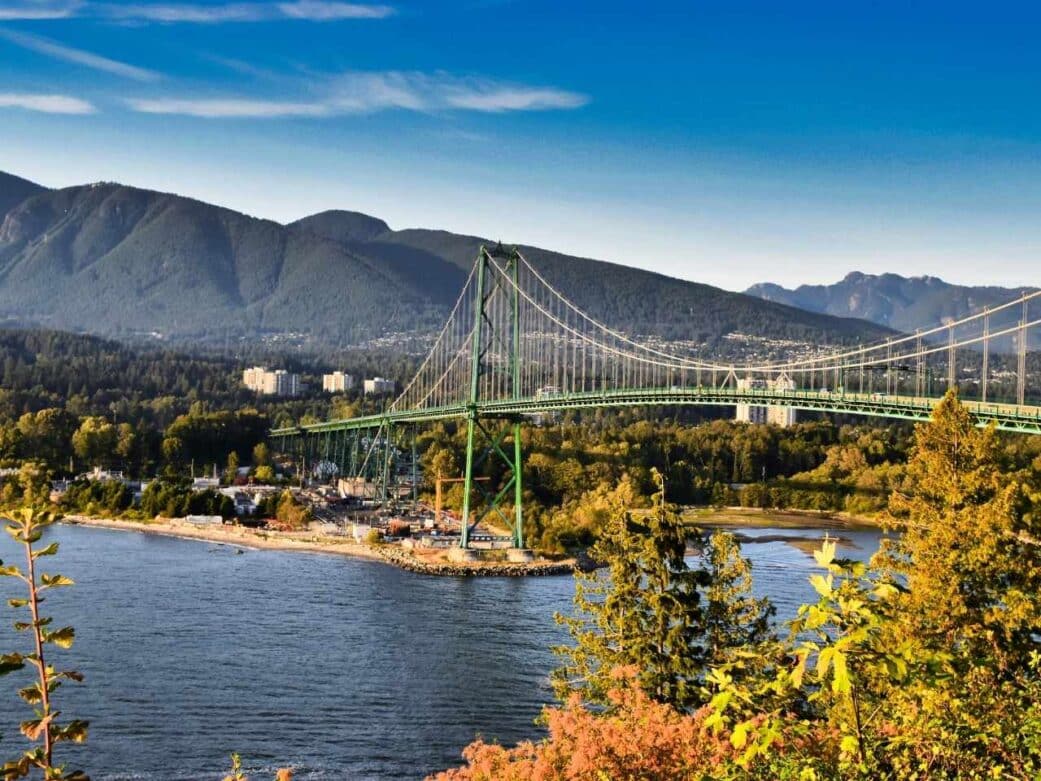 view of the bridge with the mountain at the back surrounded by green and brown leaves