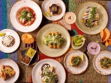 this vibrant spread of mexican dishes was taken at chancho tortilleria or a similar spot near granville island in vancouver. colorful plates, homemade tortillas, fresh salsas, and cocktails make it a perfect pick for food lovers exploring the island.